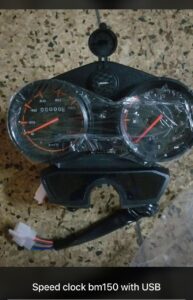 Motorcycle wheel with sprocket and tools on dirt ground in DIY repair setup.