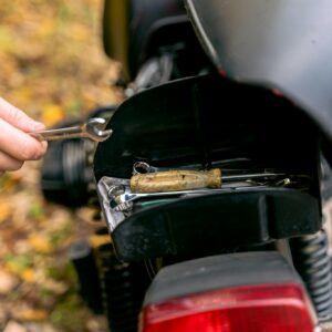 Close-up image of motorcycle tail light and tools for maintenance.