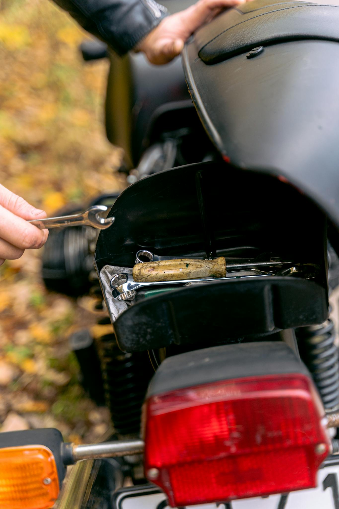 Close-up image of motorcycle tail light and tools for maintenance.