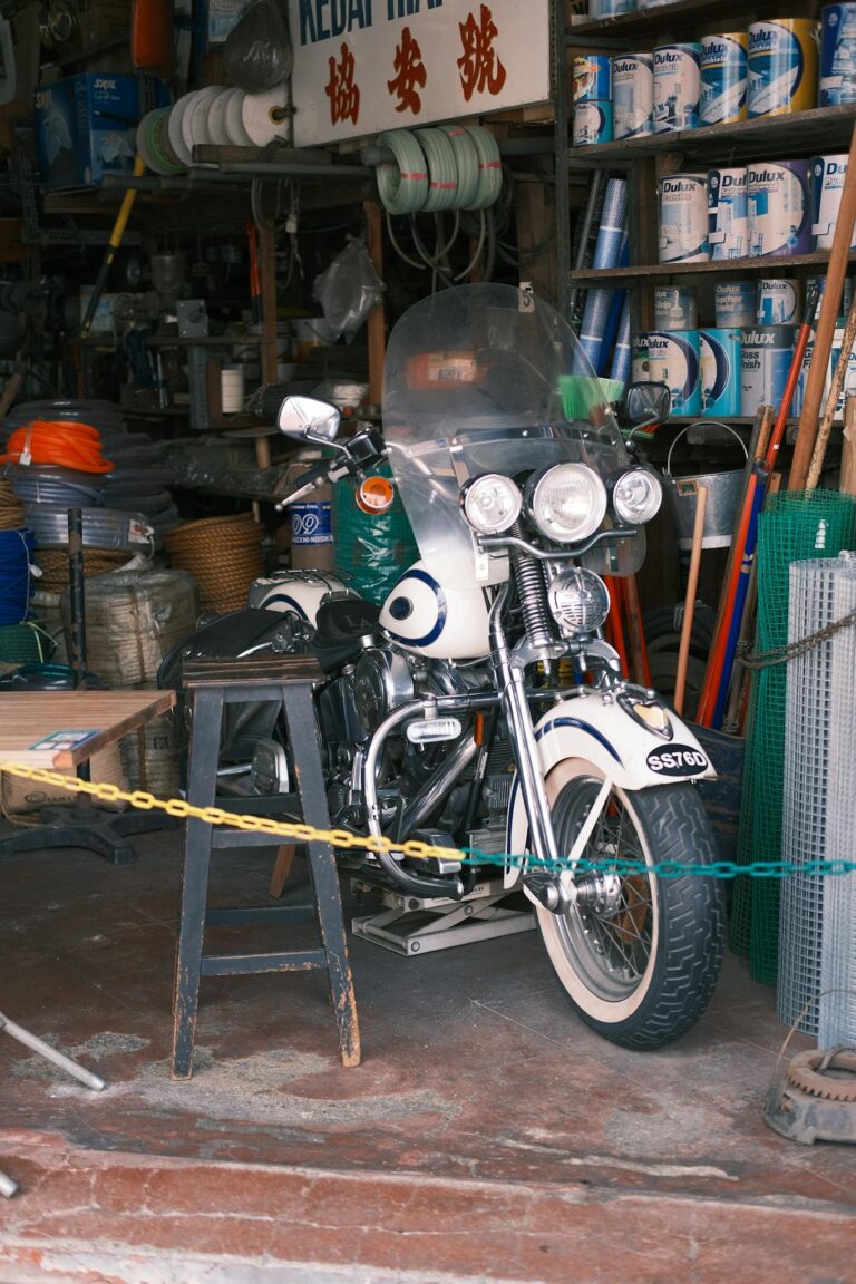 Vintage motorcycle with tools and supplies in a cluttered workshop, showcasing a retro vibe.