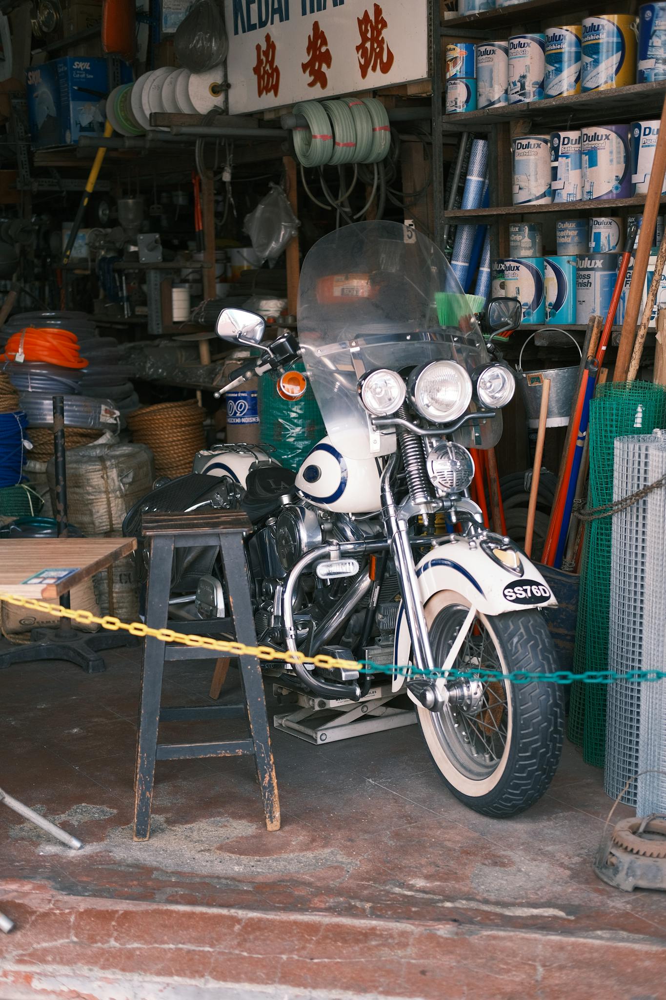 Vintage motorcycle with tools and supplies in a cluttered workshop, showcasing a retro vibe.